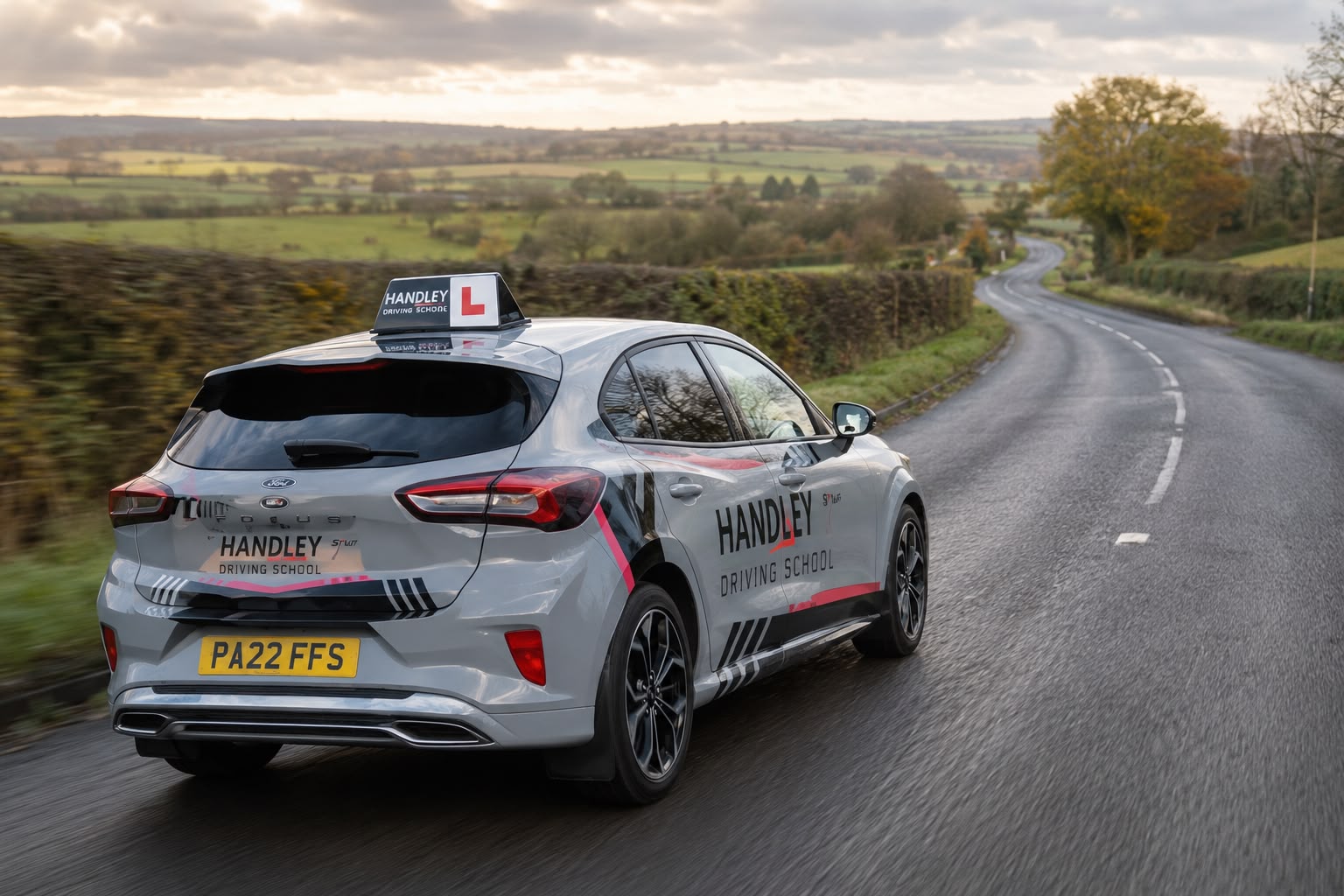 A Handley Driving School learner car on a rural road at dusk